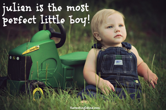 Baby boy in overalls near a toy tractor